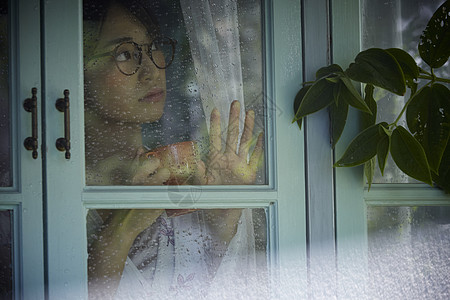 雨天女生看着窗外的景色图片素材