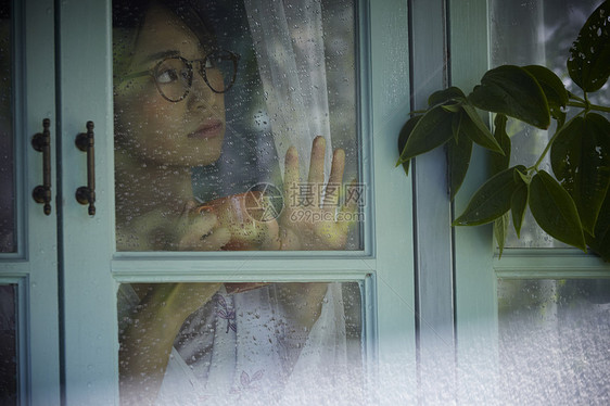 雨天女生看着窗外的景色图片