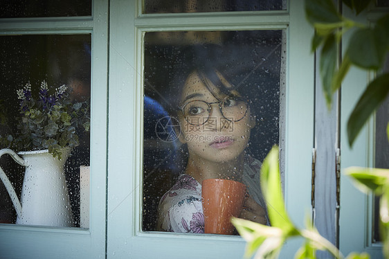 雨天女人在家里度过图片