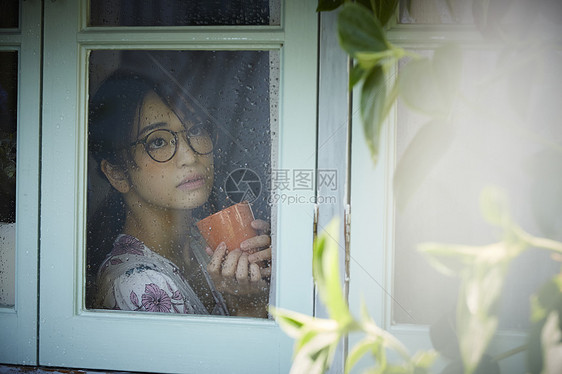 雨天女人在家里度过图片