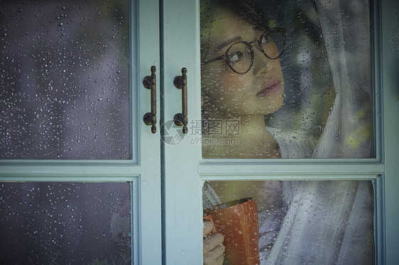 下雨天在家的孤独女性图片