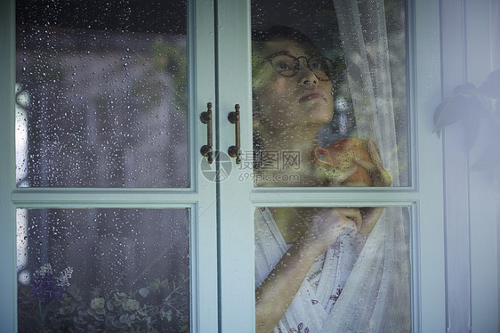 下雨天在家的孤独女性图片