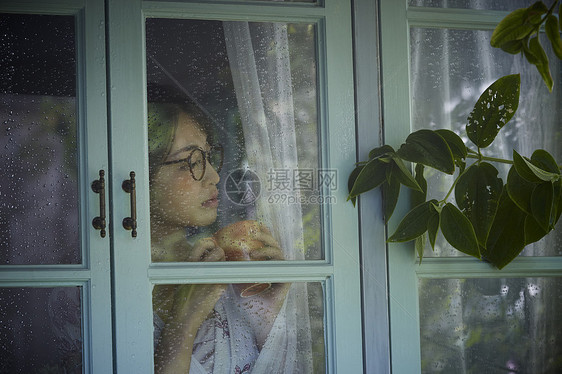 下雨天在家的孤独女性图片