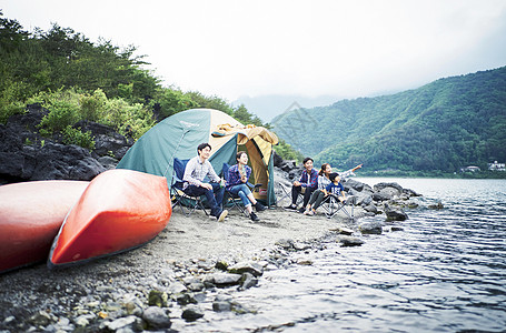 在湖泊边搭帐篷露营的一家人图片