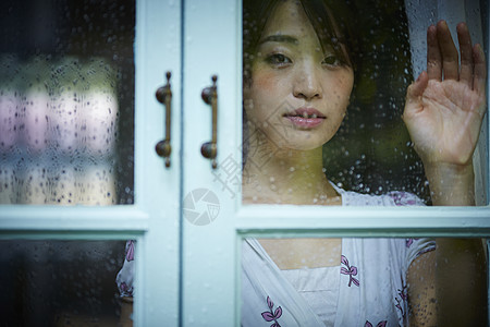 雨天女人在家里度过图片