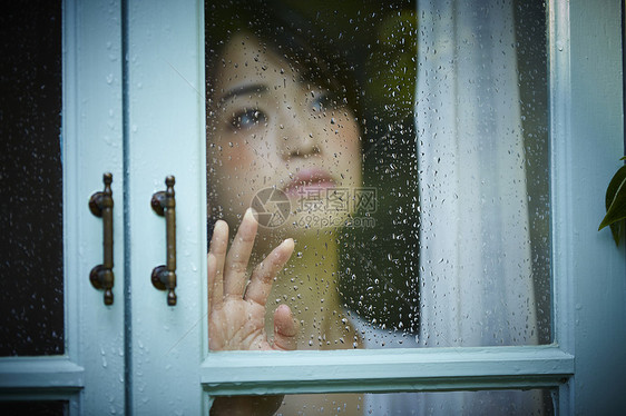 雨天女人在家里度过图片