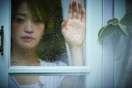 雨天女人在家里度过图片