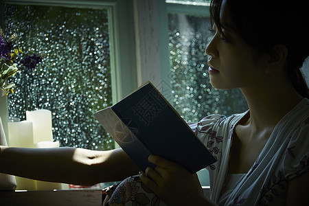 下雨天靠在窗边发呆的孤独女性图片