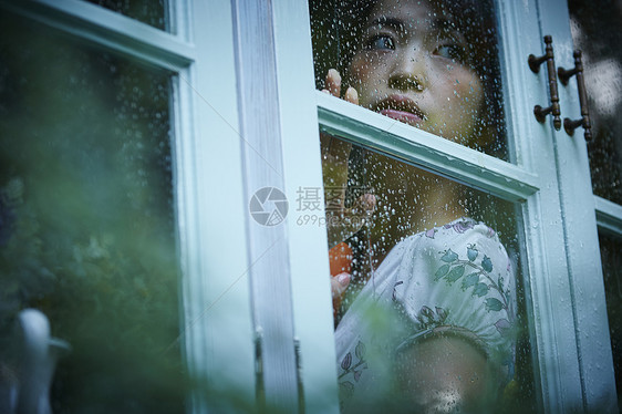 下雨天靠在窗边发呆的女性图片