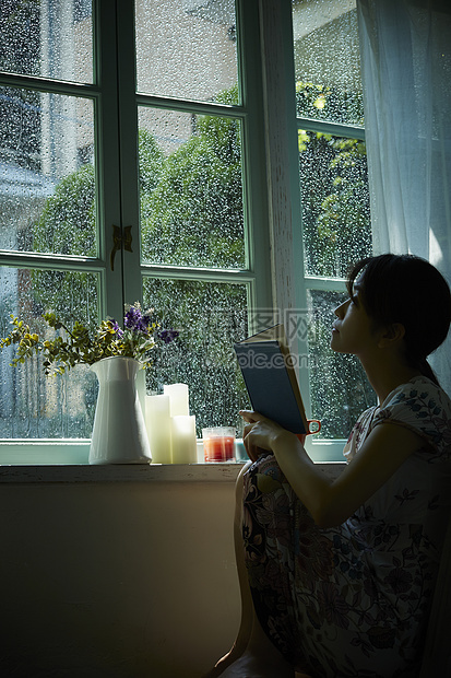 下雨天在窗边放松的女孩图片