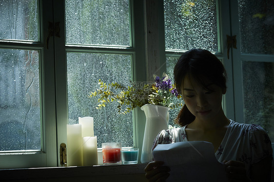 下雨天在窗边放松的女孩图片