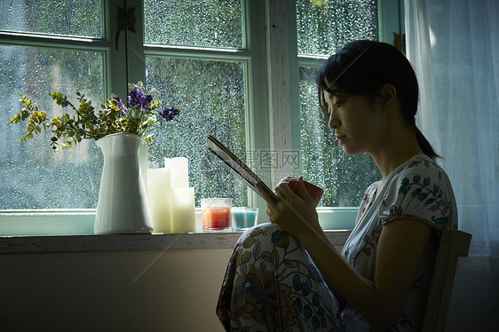 下雨天在窗边放松的女孩图片