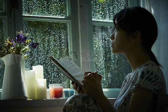 下雨天在窗边放松的女孩图片