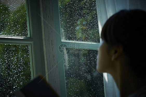 雨夜看向窗外的女青年图片