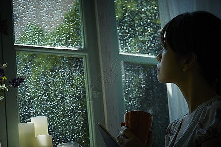 下雨天坐在窗边向外看的女生图片