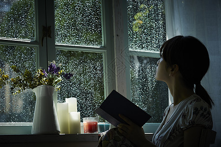 雨天在家看书休息的女青年图片