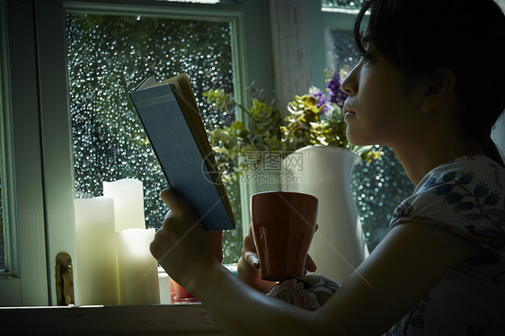 雨天居家看书的女青年图片