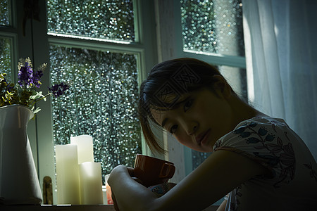 下雨天在家放松喝茶的女青年图片