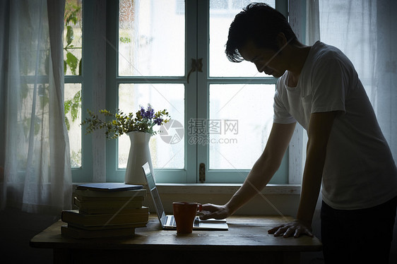 下雨天在室内办公的男性图片