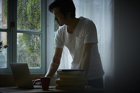 下雨天在室内办公的男性图片