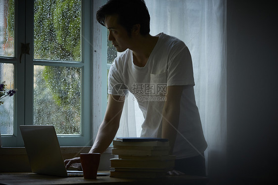 下雨天在室内办公的男性图片