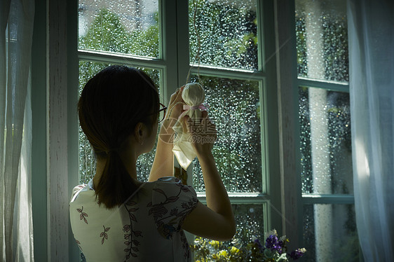 下雨天在家的年轻女性图片