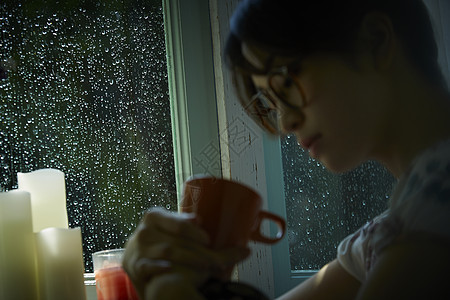 下雨天在家的年轻女性图片