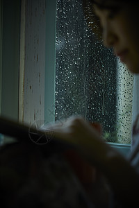 下雨天在家的年轻女性图片