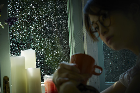 下雨天在家的年轻女性图片
