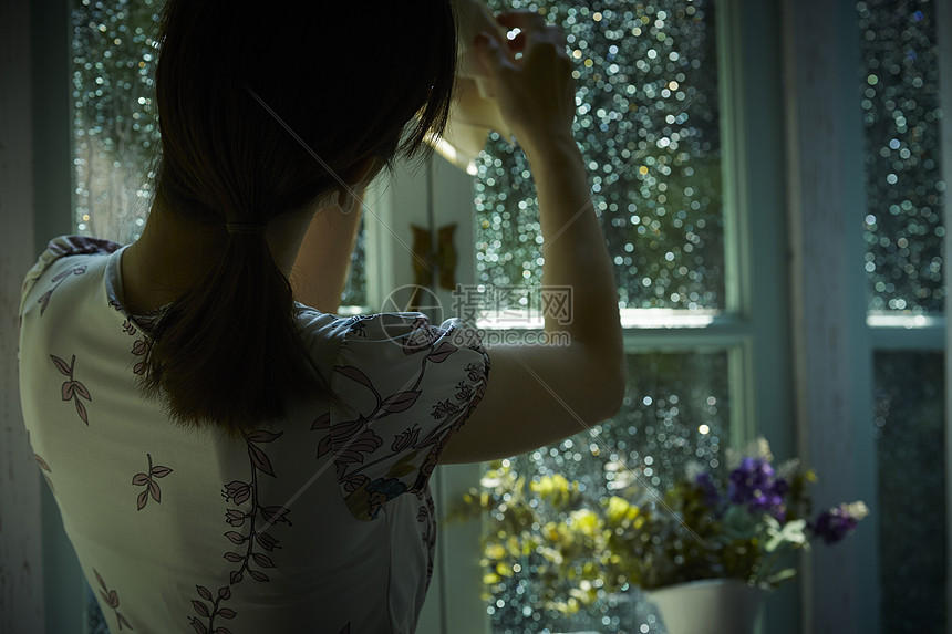 下雨天在家的年轻女性图片