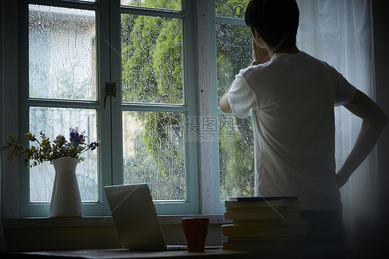 下雨天在室内的孤独男性图片