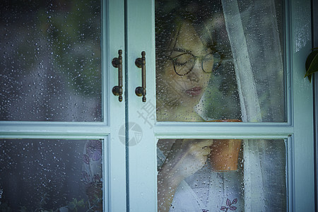 下雨天在室内的孤独女性图片