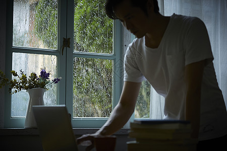 下雨天在室内的孤独男性图片