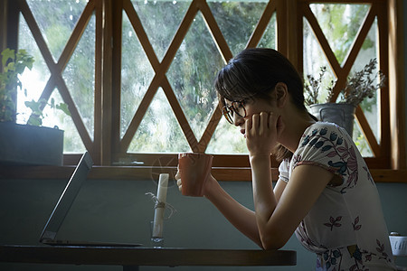 下雨天在室内的孤独女性图片