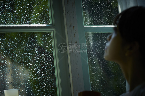 下雨天在室内的孤独女性图片