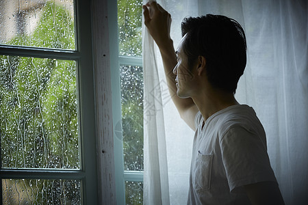下雨天在室内的孤独男性图片