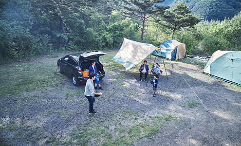 户外扎帐篷享受露营的家族图片