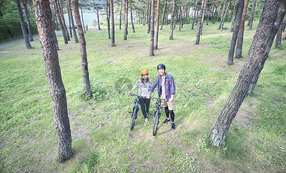 森林里戴着头盔骑登山车的夫妇图片