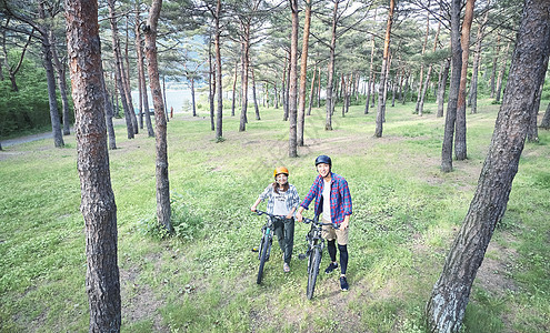 森林里戴着头盔骑登山车的夫妇图片