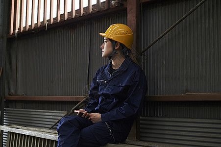 穿着工作服坐在一旁休息的蓝领工人图片