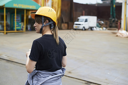 戴着头盔的女性工人背影图片