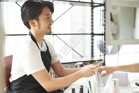 男店员在给客户修美甲图片