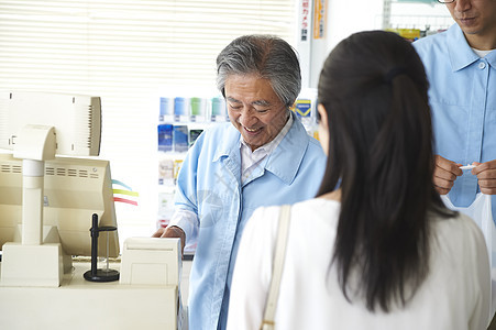 便利店营业员为顾客结账图片