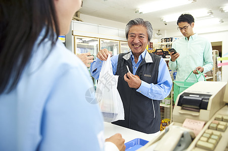 日本药妆店等顾客在便利店的收银台等待排队背景