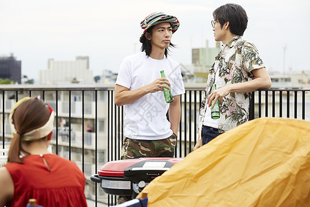 青年朋友在阳台上喝啤酒聊天图片