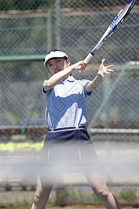 室外网球场打网球的青年女性图片