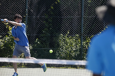 户外训练场打网球的青年男性图片