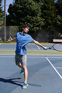 网球训练场打网球的成年男子图片