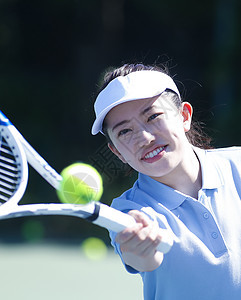 享受室外遮光板打网球的女人图片