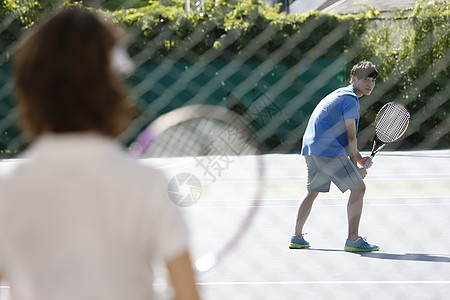 下级上课老年人男人和女人在网球场背景